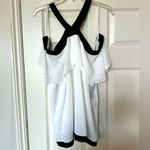 White cold shoulder INC blouse with ruffle and black trim.